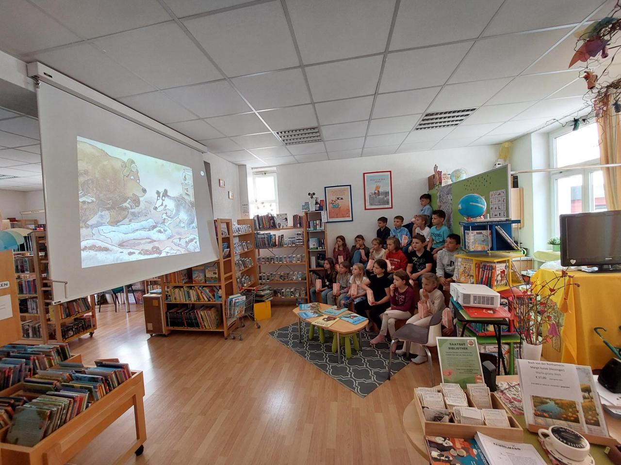 Kinder sehen ein Bilderbuchkino an