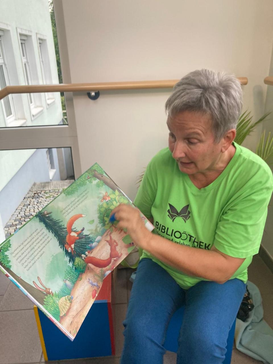 Frau mit Bilderbuch lesend