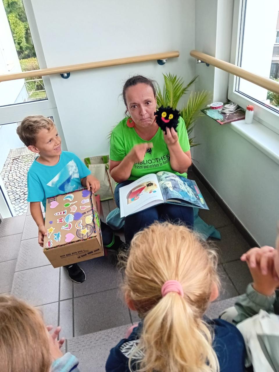 Frau zeigt Kindern ein selbstgemachtes Männchen