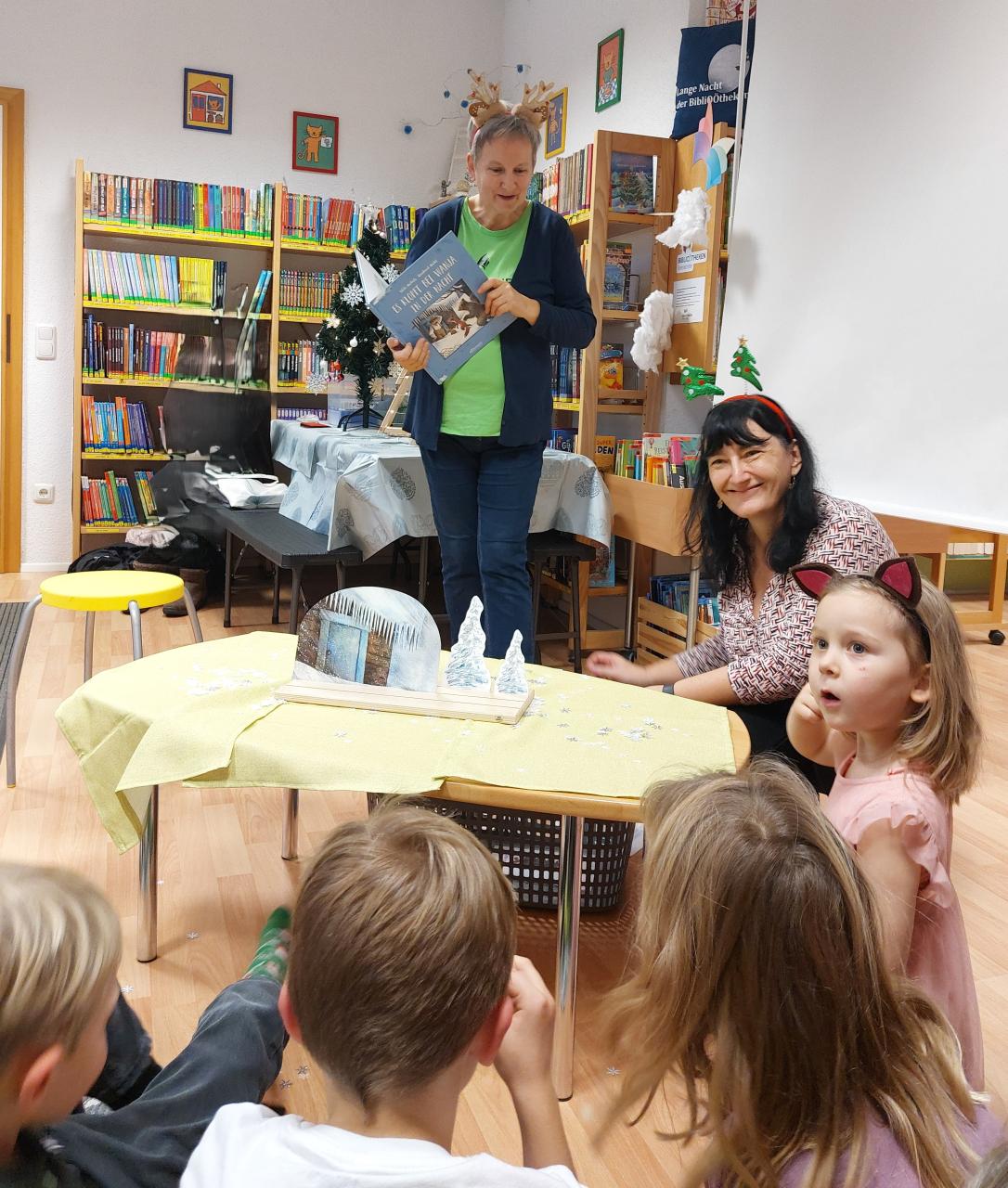 Zwei Frauen lesen Kindern etwas vor