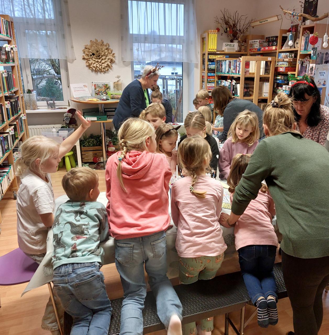 Viele Kinder sitzen an langen Tischen und basteln