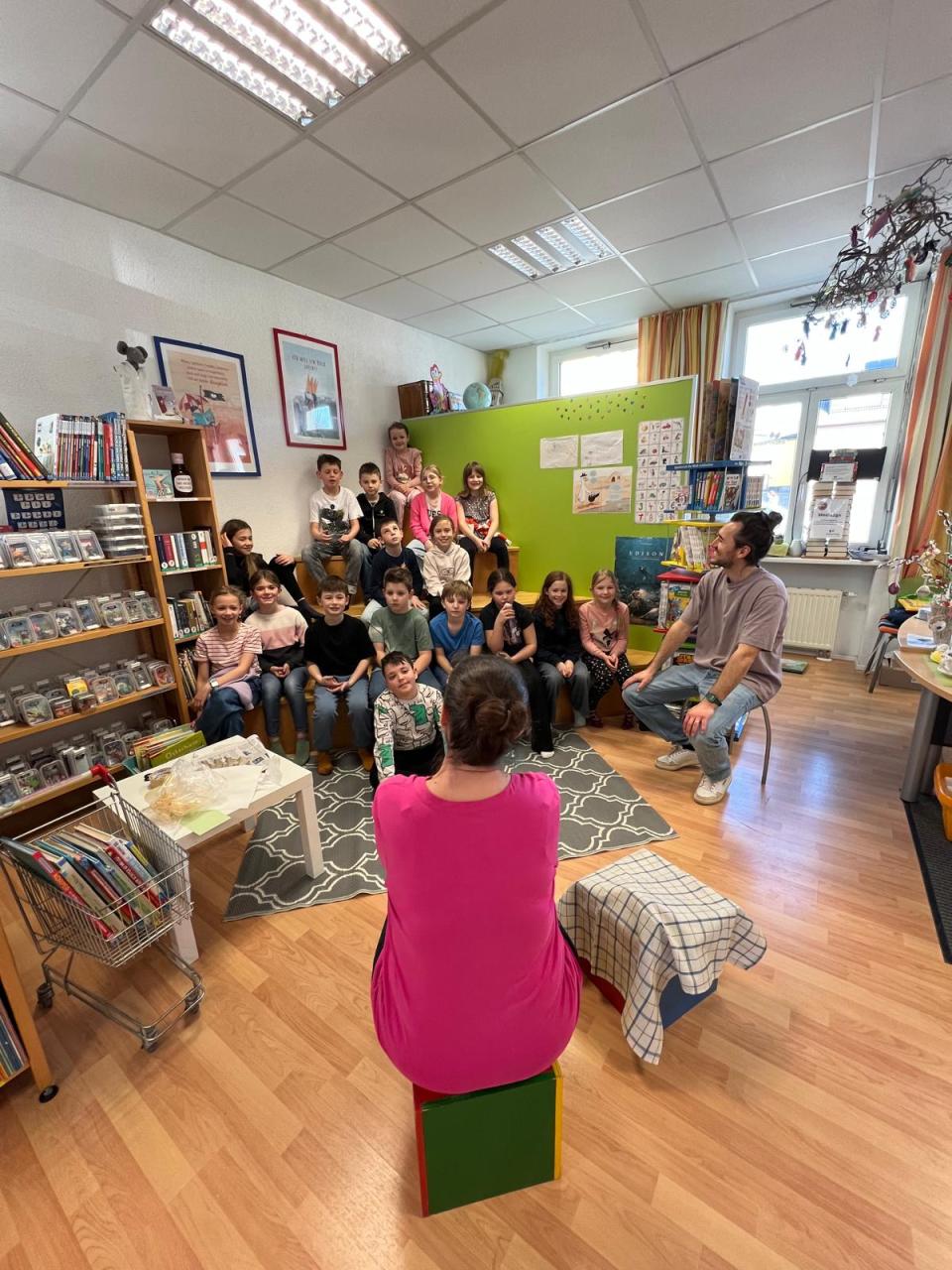 Kinder sitzen auf einer Treppe, Frau erzählt 