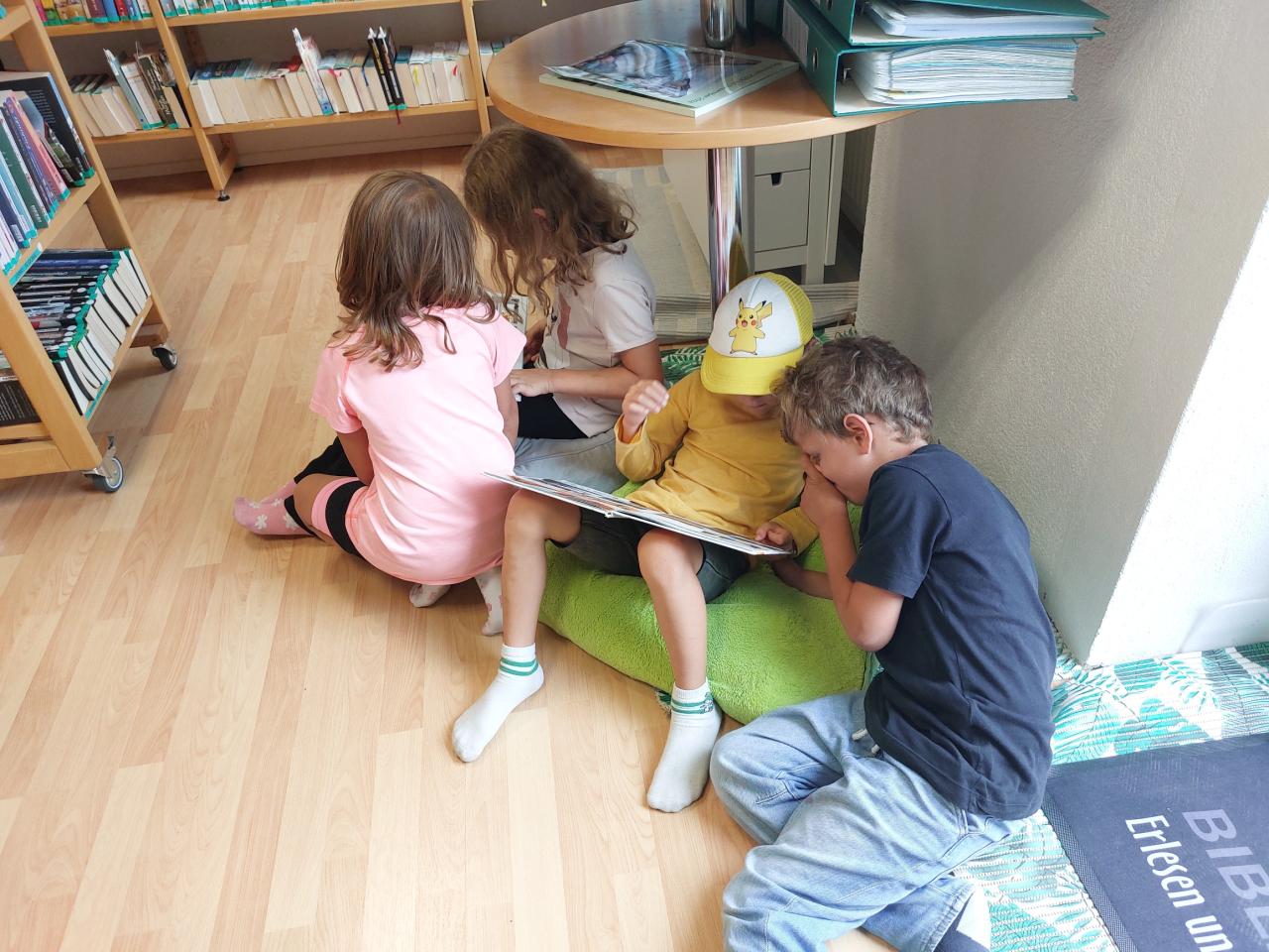 Kinder schmökern am Boden