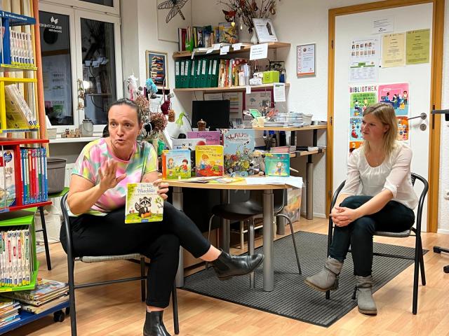 Zwei Frauen sitzen in der Bücherei und stellen Literatur zur Schnullerentwöhnung vor